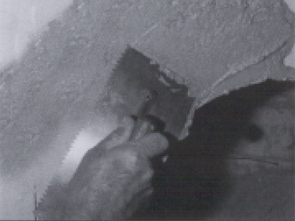 A hand and trowel applying Power Plant J-3000 mortar